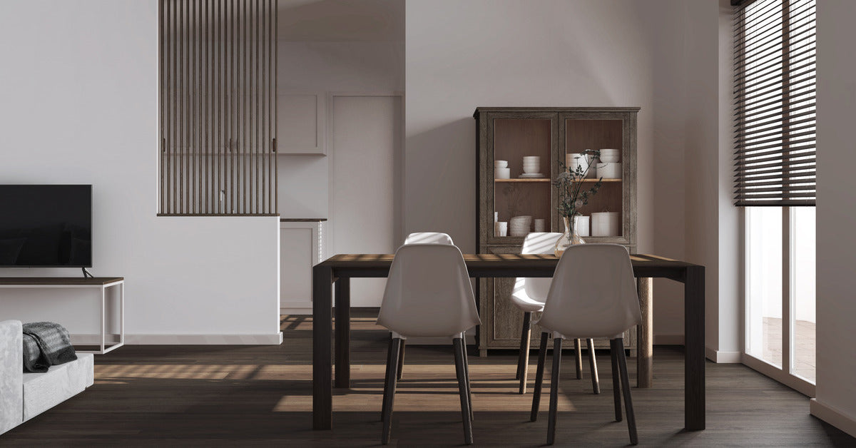 A modern dining room with a minimalistic style. There is a cabinet behind the table with some dishes inside of it.