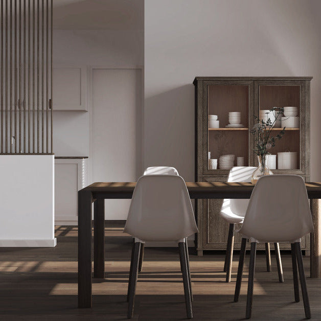 A modern dining room with a minimalistic style. There is a cabinet behind the table with some dishes inside of it.