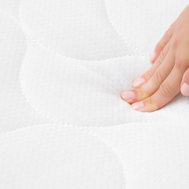 A person, up close and pressing down on a mattress. They only use three fingers to press into the mattress.